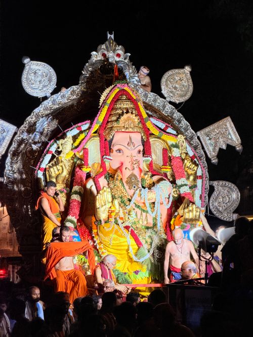 Free A grand Ganesh idol illuminated during a festive night celebration with devotees. Stock Photo
