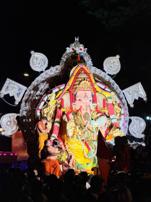 Free Vibrant Ganesh Chaturthi festival with decorated Ganesha idol and people celebrating at night in Mumbai. Stock Photo