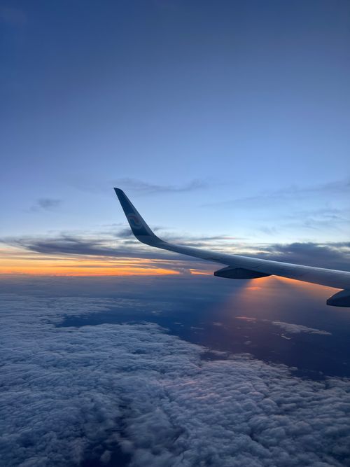 Free View of airplane wing and clouds during a breathtaking sunrise over Chongqing, China. Stock Photo