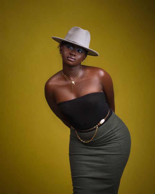 Free Fashionable portrait of a woman in a hat with stylish accessories. Studio shot on yellow background. Stock Photo