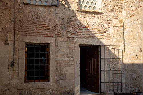 Free A beautiful historic stone wall with arched windows and doorway under sunlight in Istanbul. Stock Photo