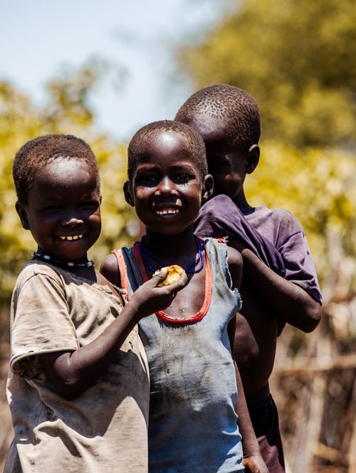 Free Three smiling children enjoying a sunny day, creating a heartwarming scene of happiness. Stock Photo
