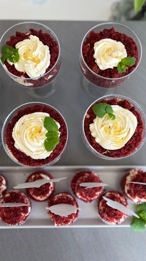 Free Delicious red velvet cupcakes and desserts with cream cheese frosting, garnished with mint leaves. Stock Photo