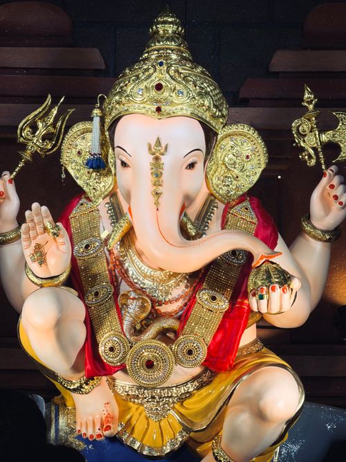 Free Stunning statue of Lord Ganesha adorned with gold and traditional attire in Pune, India. Stock Photo