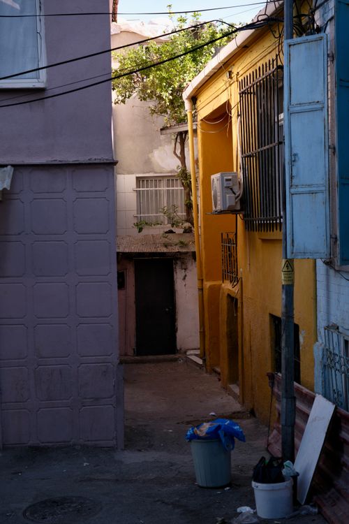 Free Captivating view of an alley in İzmir, Türkiye, featuring vibrant colored walls and household items. Stock Photo