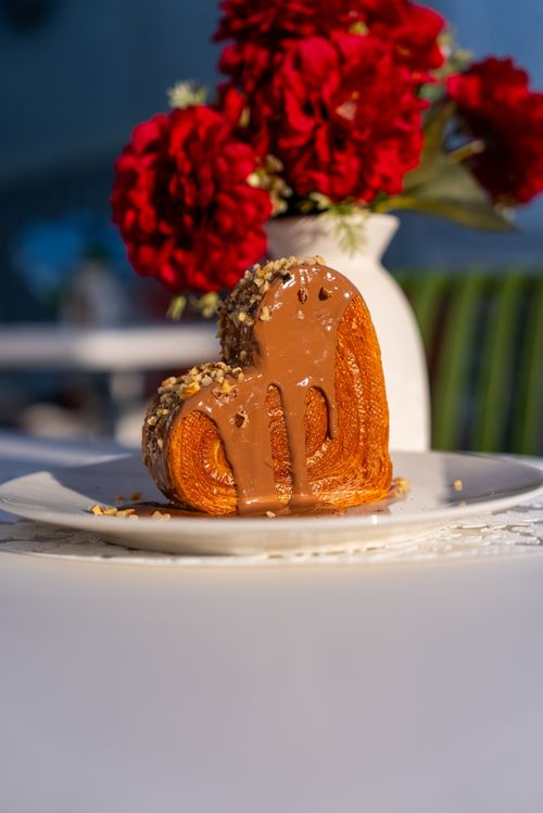 Free Delicious heart-shaped pastry drizzled with chocolate and garnished with nuts, perfect for a sweet treat. Stock Photo
