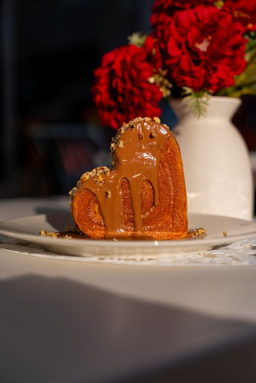 Free A delicious heart-shaped dessert topped with caramel and nuts, perfect for special occasions. Stock Photo
