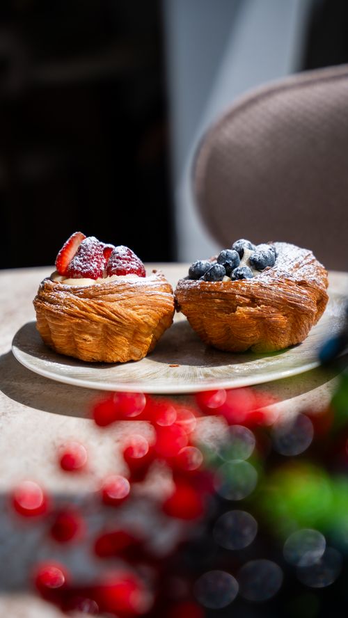 Free Tantalizing croissants topped with fresh strawberries and blueberries, captured on a sunny table in Türkiye. Stock Photo