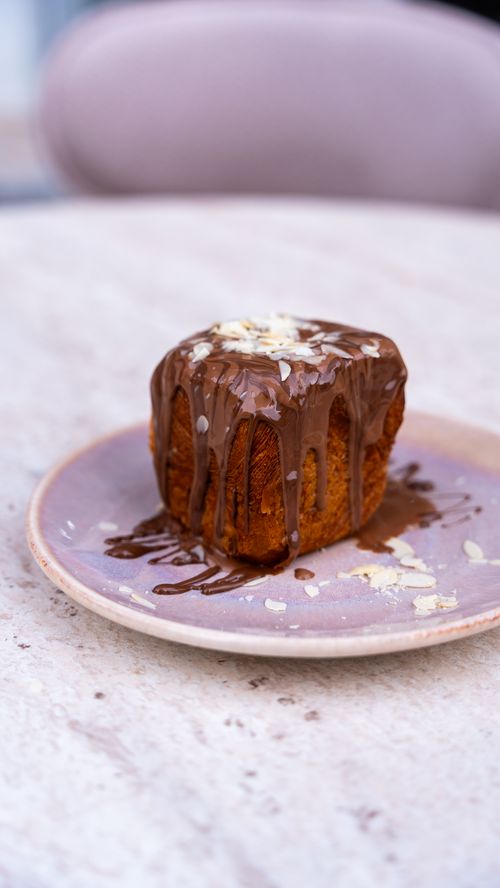 Free Mouthwatering cake drizzled with chocolate and topped with almonds. Stock Photo