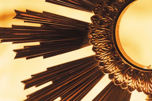 Free Close-up of a decorative golden sunburst with rich details and warm lighting. Stock Photo