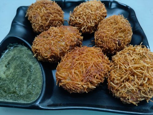 Free Delicious crispy fried snacks served with green chutney on a black plate. Stock Photo
