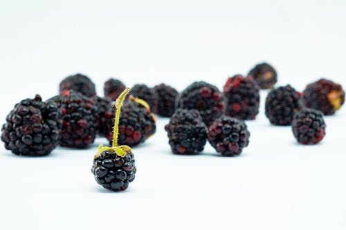 Free Black Round Fruit On White Surface Stock Photo