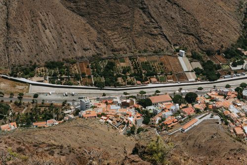 Free A breathtaking view of Valle Gran Rey featuring terracotta roofed houses and lush gardens. Stock Photo