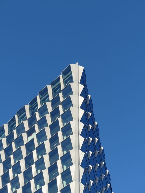 Free Striking modern facade of a building in Brussels under a clear blue sky. Stock Photo