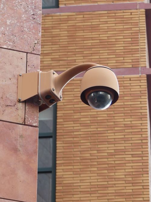 Free A modern security camera mounted on a brick wall in Brussels, Belgium. Stock Photo