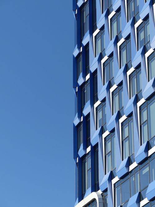 Free Architectural detail of a modern blue building facade in Brussels, showcasing geometric design against a clear sky. Stock Photo