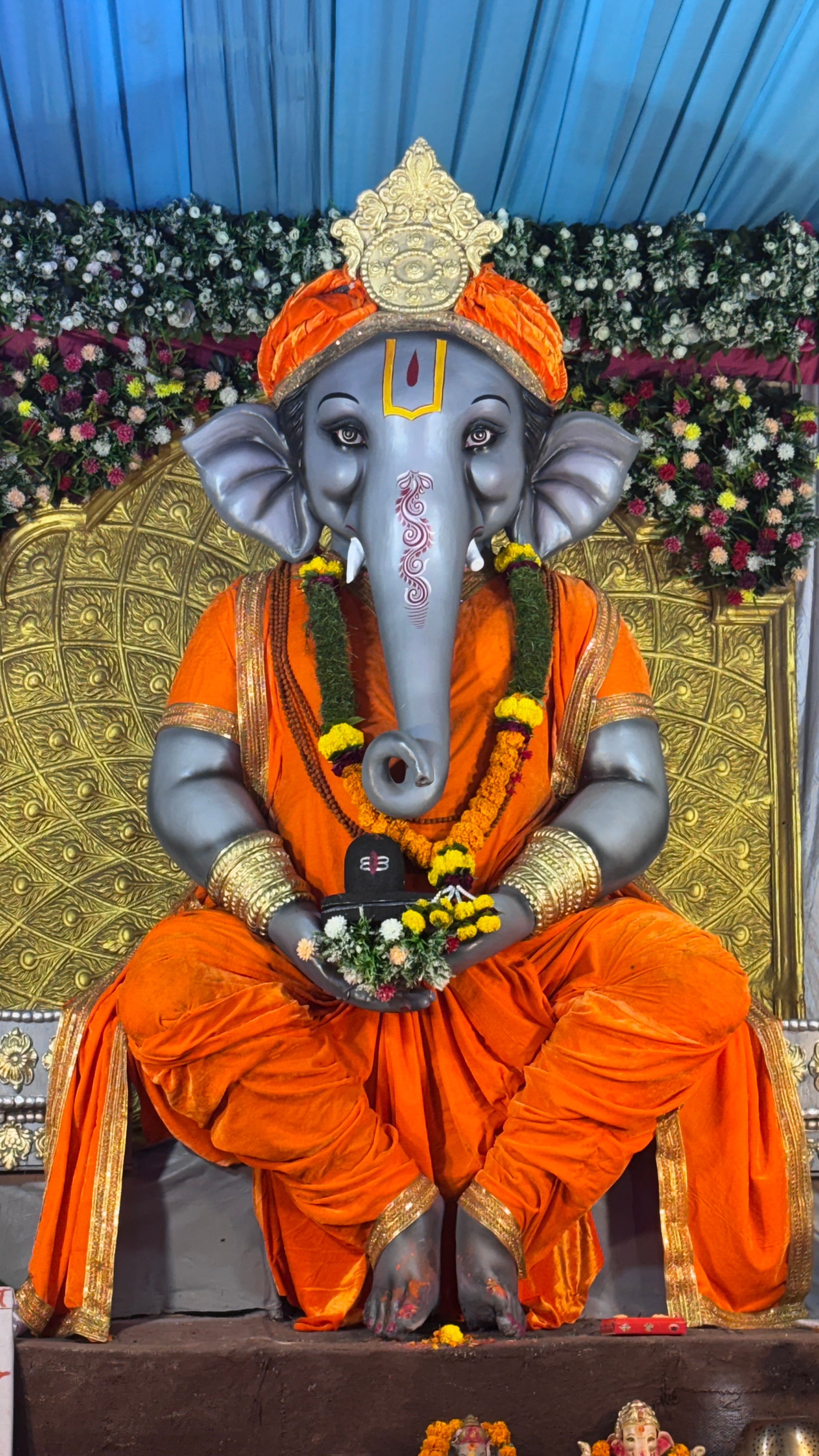 Intricately crafted Lord Ganesha statue adorned with vibrant flowers and decorations.