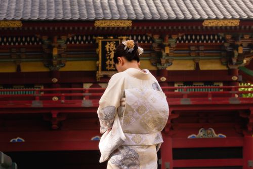 Free A woman in a kimono stands gracefully before a traditional Japanese temple building. Stock Photo
