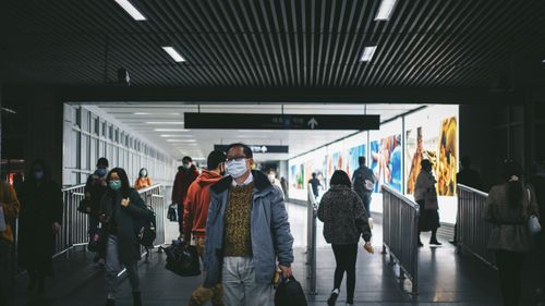 Free People in Shanghai subway station wearing masks, reflecting pandemic precautions. Stock Photo