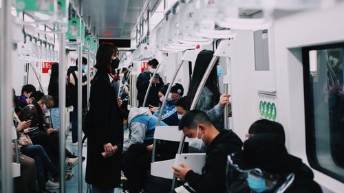 Free Commuters wearing masks on a subway train, reflecting pandemic public transportation usage. Stock Photo