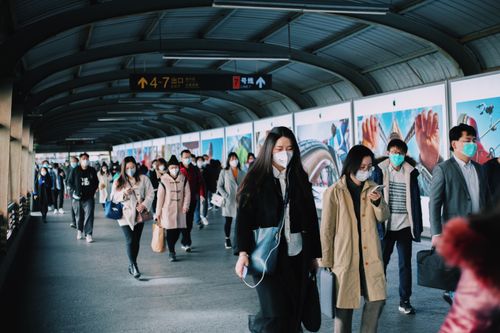 Free Masked commuters walking through a subway station in Shanghai, China, reflecting pandemic life. Stock Photo