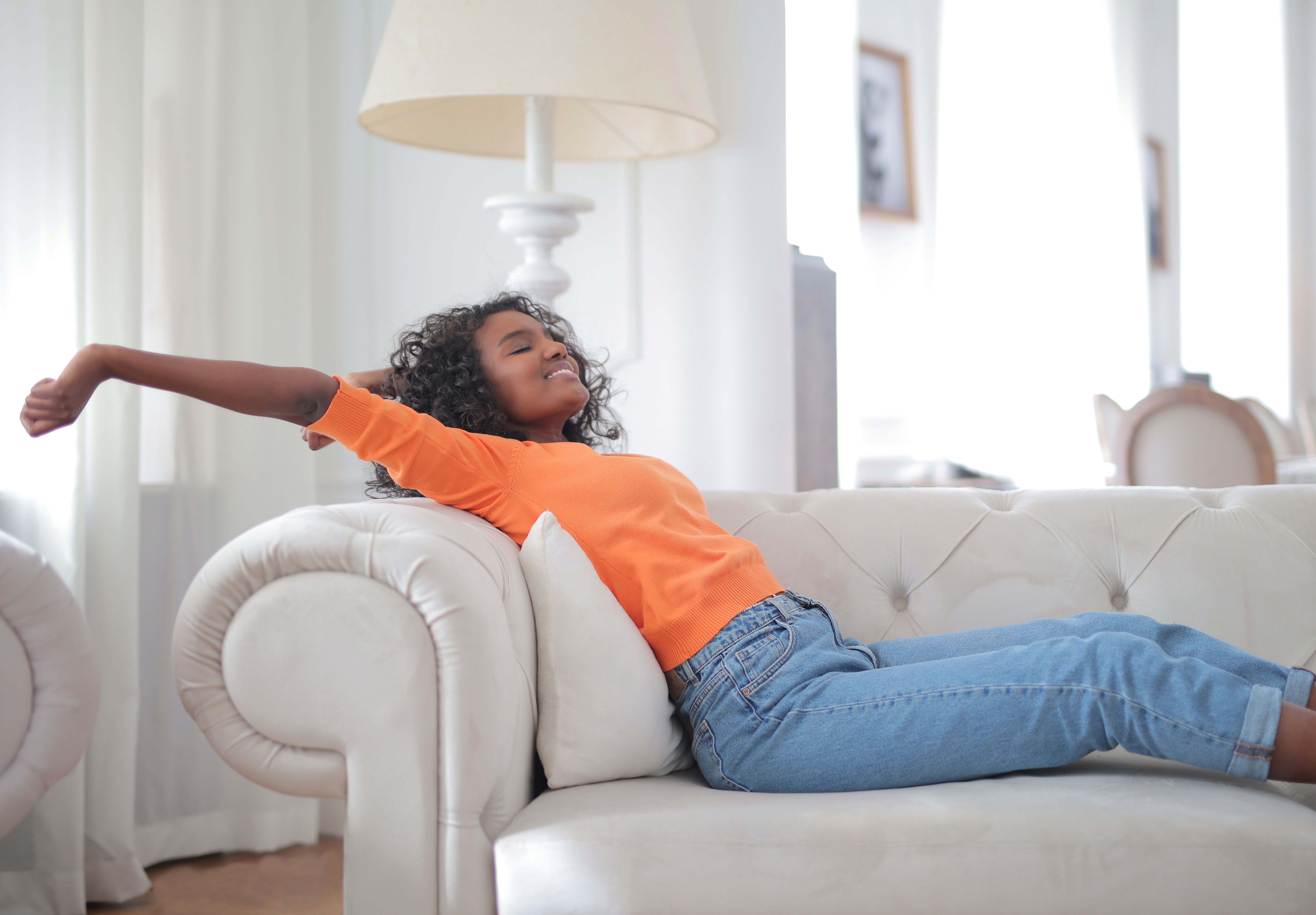 Happy woman doing a quick stretch in her living room during a work break