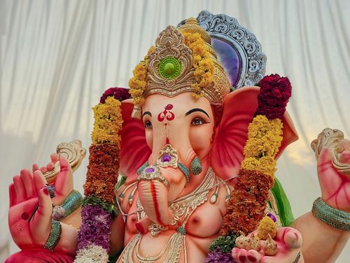 Free Colorful Ganesha idol with floral garlands in a sacred, spiritual setting, perfect for festivals. Stock Photo