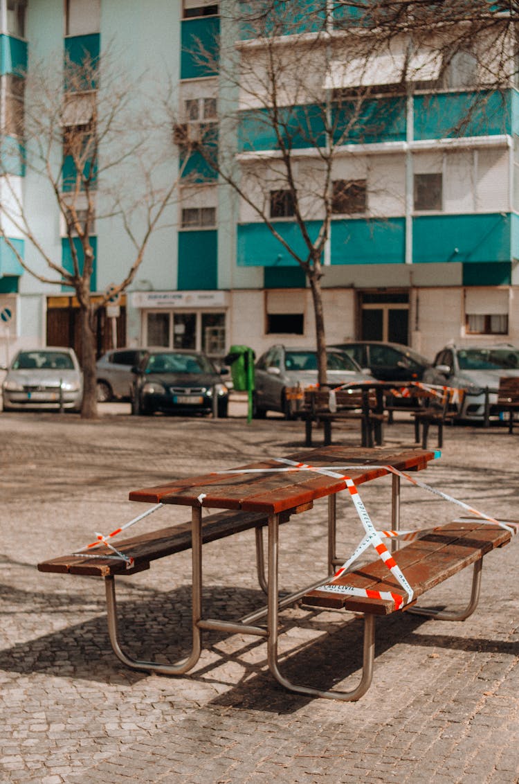 Brown Wooden Picnic Table Wrapped With Barricade Tape