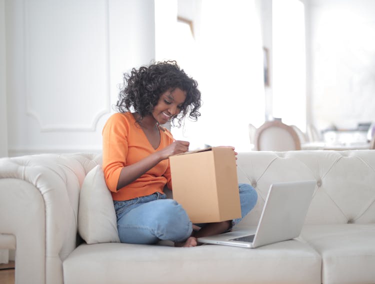 Happy Black Lady With Laptop Opening Parcel