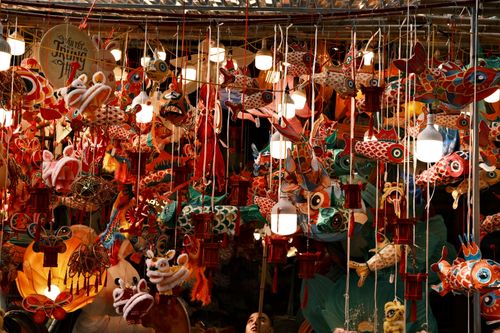 Free Colorful lanterns and decorations hang tightly in a bustling market for the Mid-Autumn Festival. Stock Photo