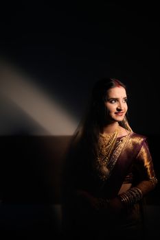 A stunning portrait of a bride in traditional Indian attire highlighting gold jewelry and rich saree fabric. - Fotografer Sidoarjo