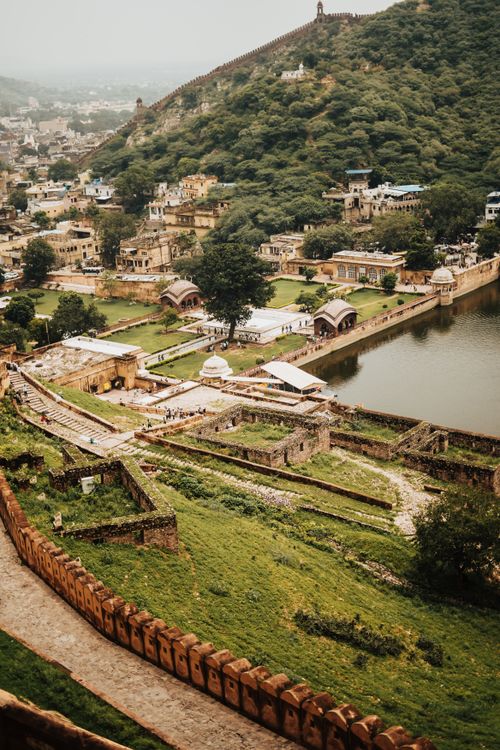Free Majestic view of Amer Fort's historic architecture and lush surroundings near a serene lake. Stock Photo