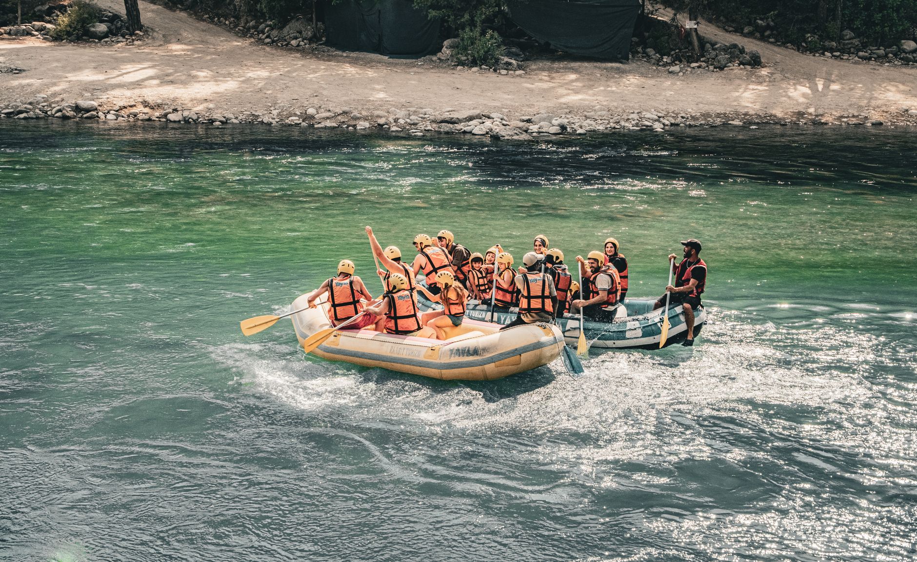 Experience the excitement of a group navigating white water rapids in an inflatable raft on a river excursion.