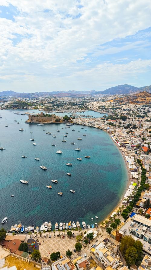 Free Stunning aerial view of Bodrum's coastline with boats, hills, and vibrant townscape. Stock Photo