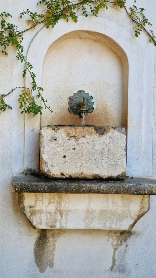 Free Rustic stone fountain with vines in Balaruc-les-Bains, Occitanie, France. Stock Photo