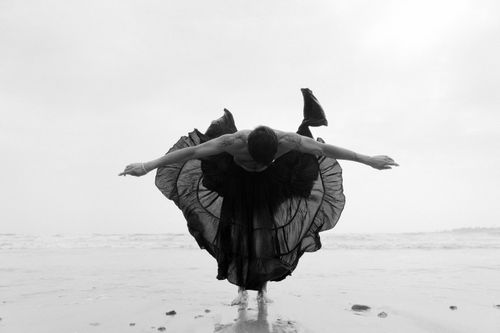 Free A captivating black and white photo of a dancer performing gracefully on the beach, embodying freedom and elegance. Stock Photo