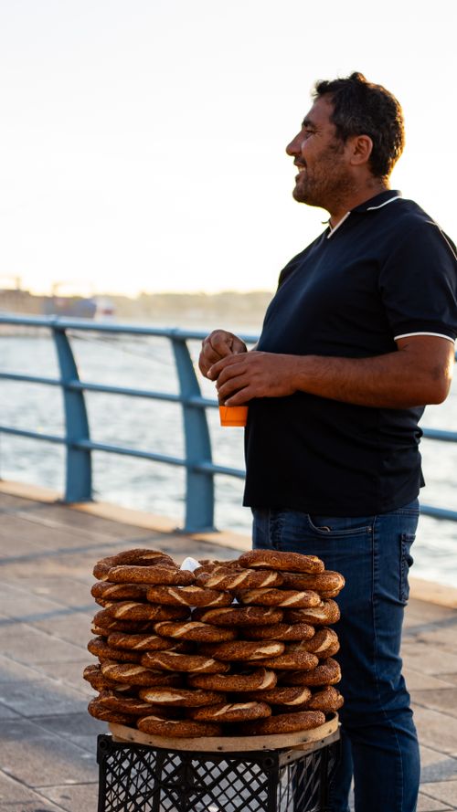 Free A street vendor sells traditional simit by the Bosphorus during a sunny day in İstanbul. Stock Photo