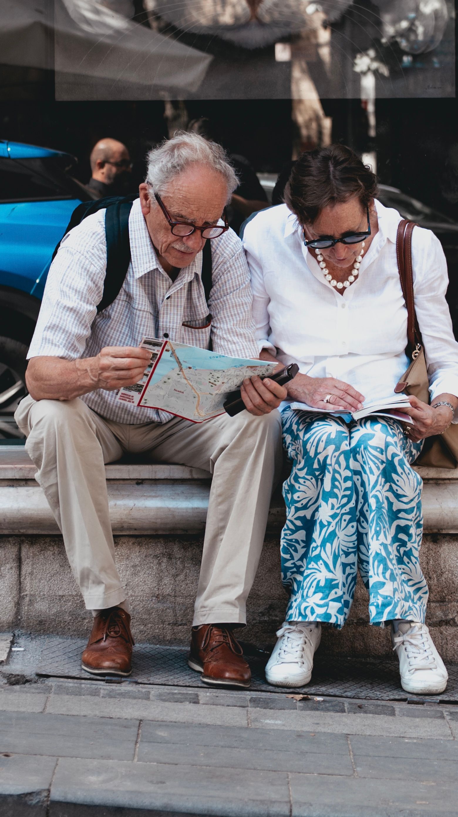Senior couple studying a map together on a city street while traveling with dementia