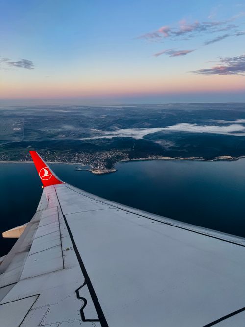 Free Aerial view of the Turkish coastline during flight at sunset, showcasing a serene seascape and vibrant sky. Stock Photo