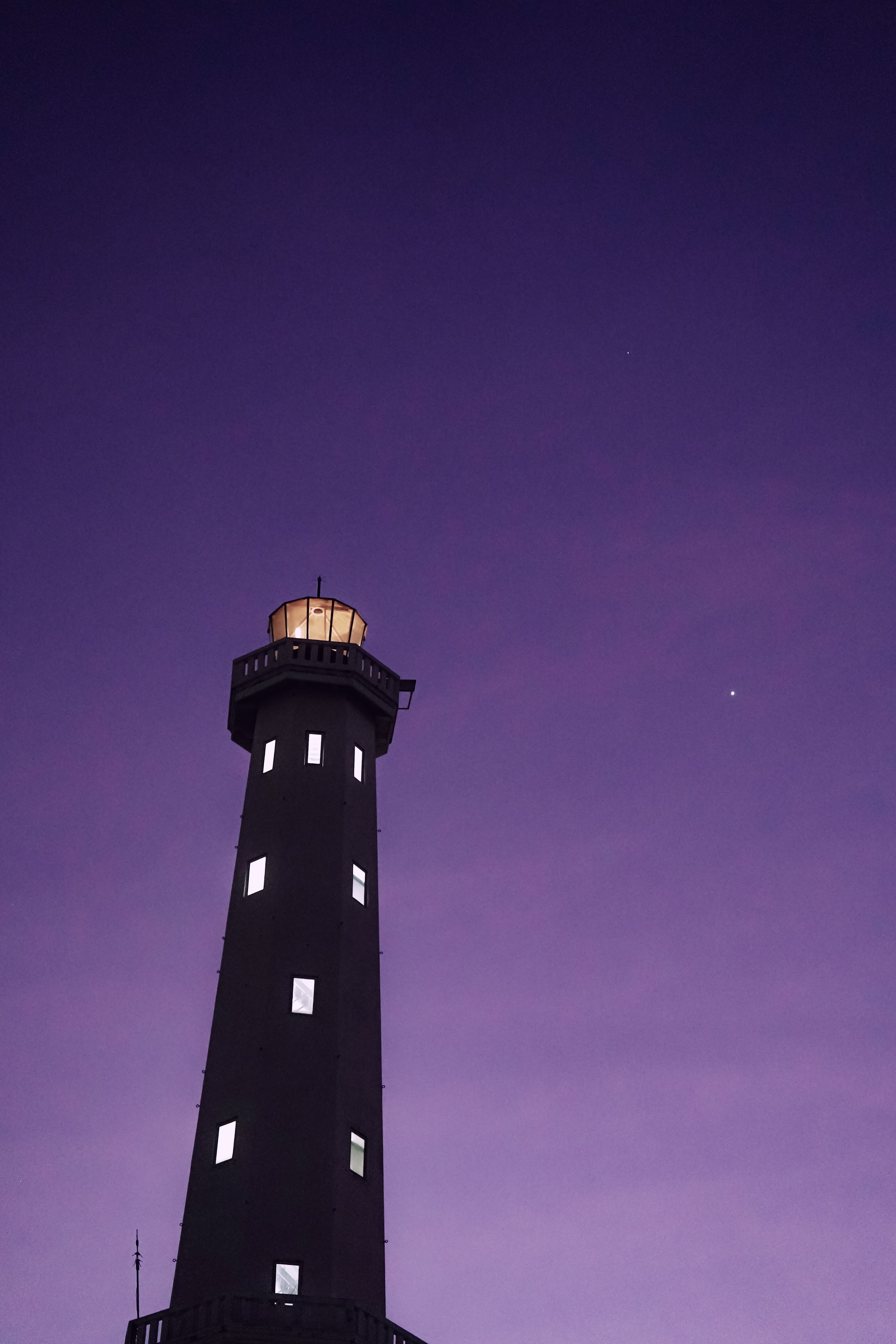 Silhouette of a lighthouse against a purple twilight sky in Kupang, Indonesia.