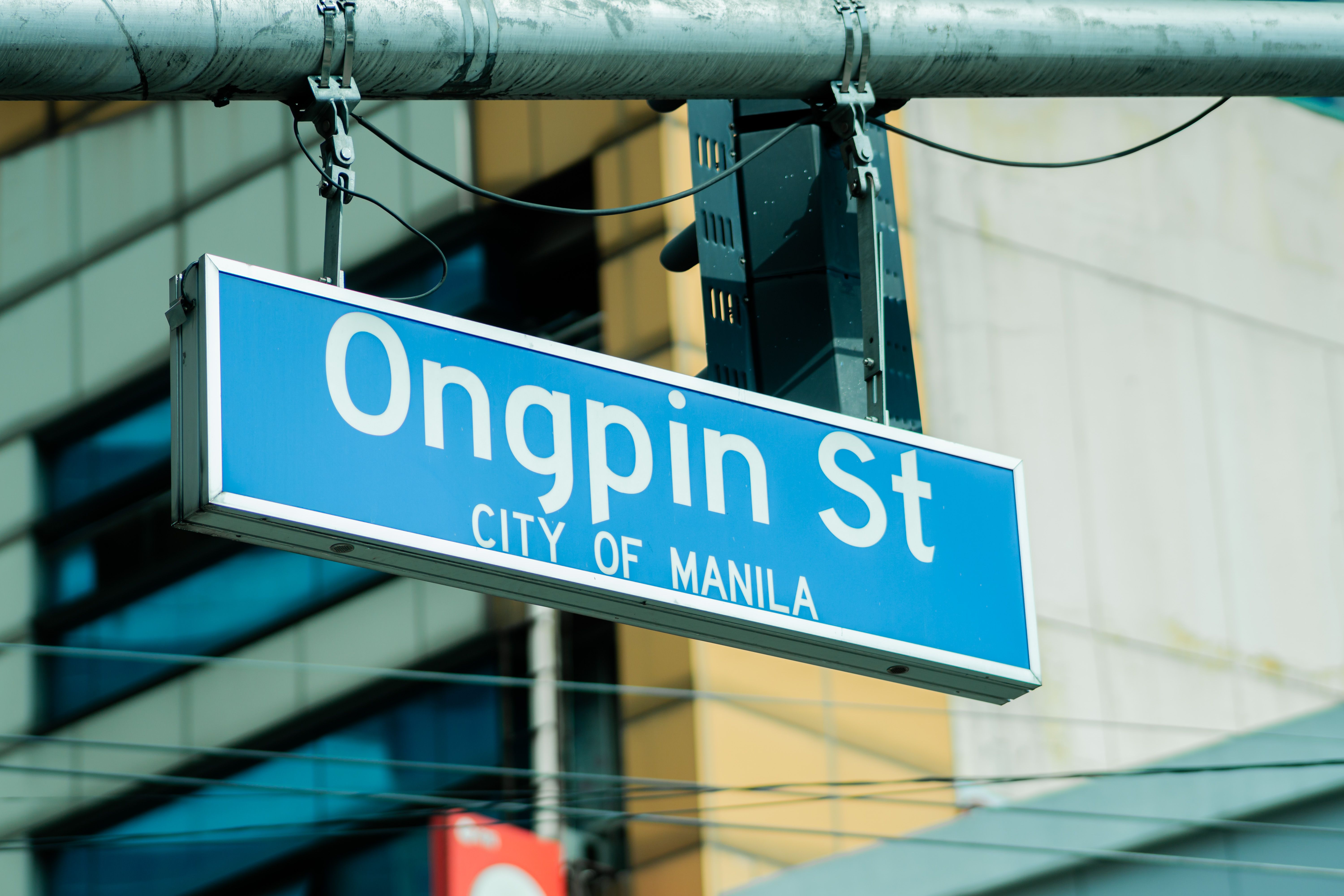 Street sign for Ongpin St in the heart of Manila, Philippines, capturing urban life.