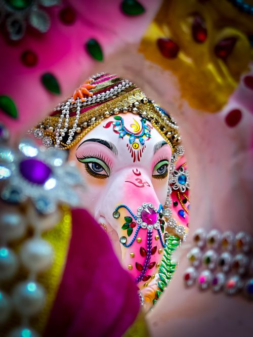 Free Colorful close-up of a richly adorned Ganesh idol with intricate jewelry and vibrant decorations. Stock Photo