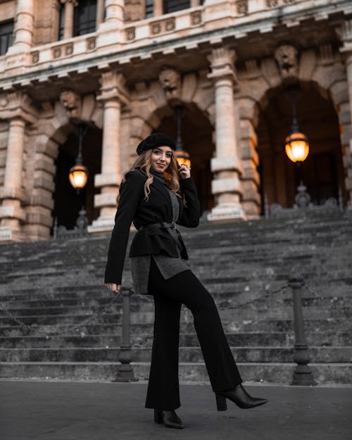 Woman In Black Coat And Black Pants Standing Near Stairs