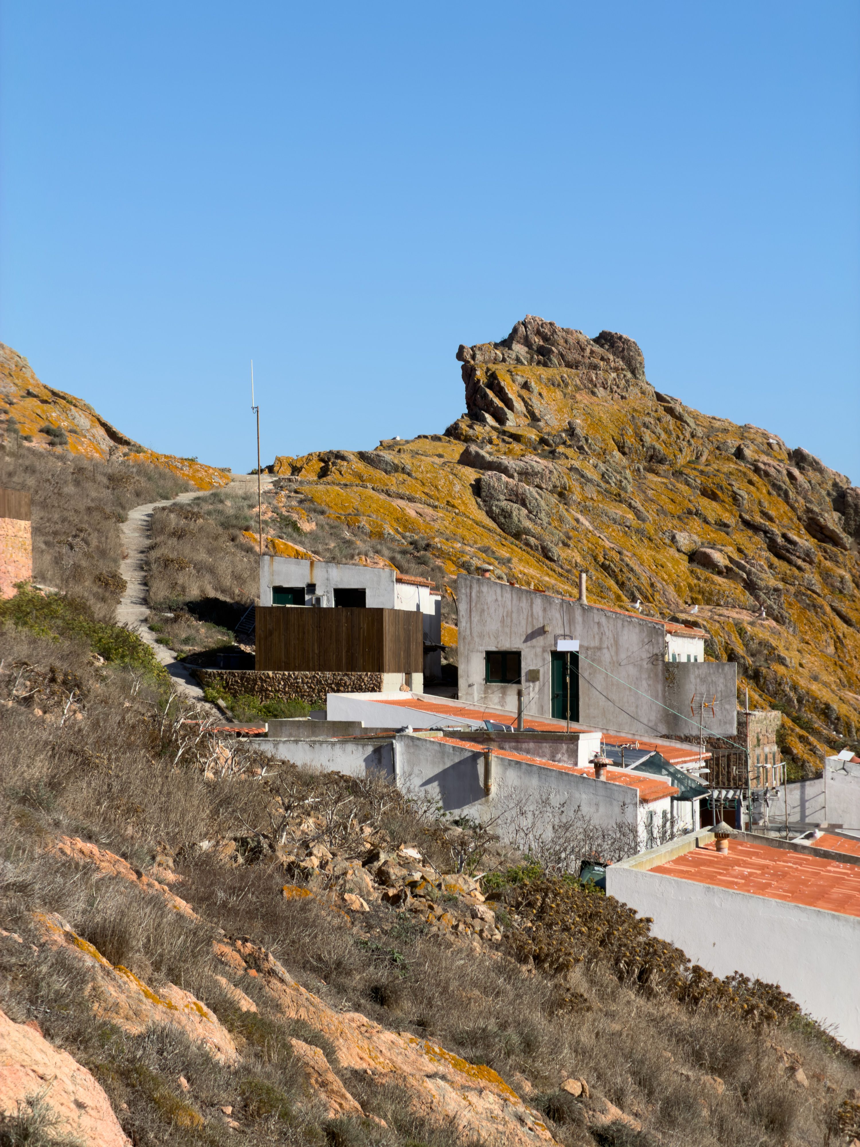 Modern structures perched on the scenic cliffs of Peniche, capturing rustic coastal charm.