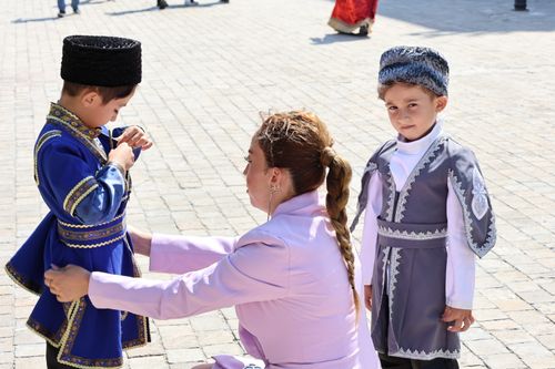 Free Children in traditional Caucasian costumes prepared for a cultural festival outdoors. Stock Photo
