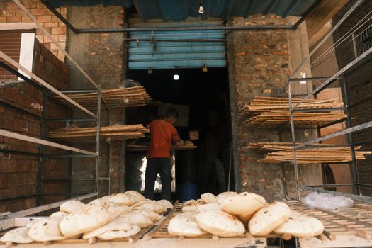 A glimpse into breadmaking in a traditional bakery in Luxor, Egypt with fresh loaves cooling.
