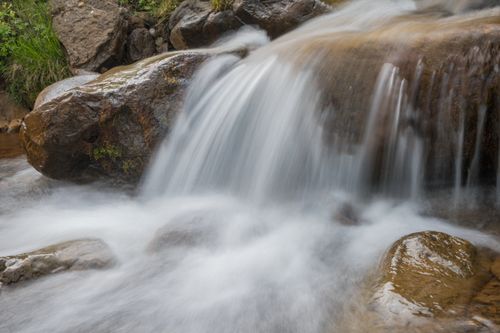 Free A peaceful waterfall cascading over rocks, creating a tranquil natural scene. Stock Photo