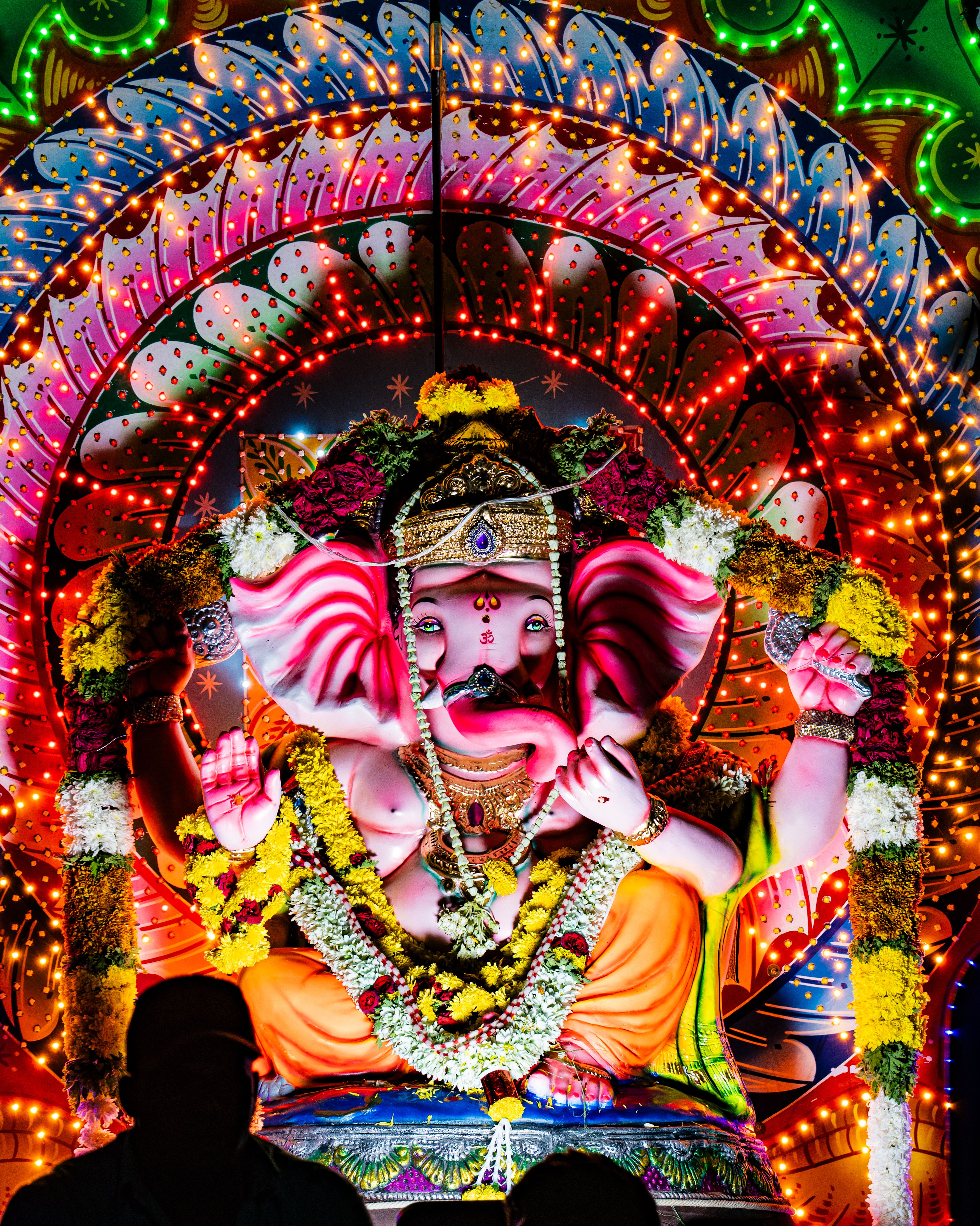 Colorful Ganesh Chaturthi festival idol adorned with lights and garlands in Bengaluru, India.