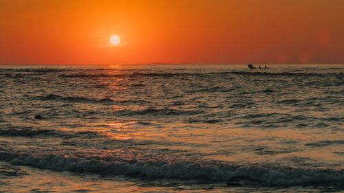 Free Mesmerizing sunset view over the ocean in Quảng Trị, Vietnam, with a lone fishing boat. Stock Photo
