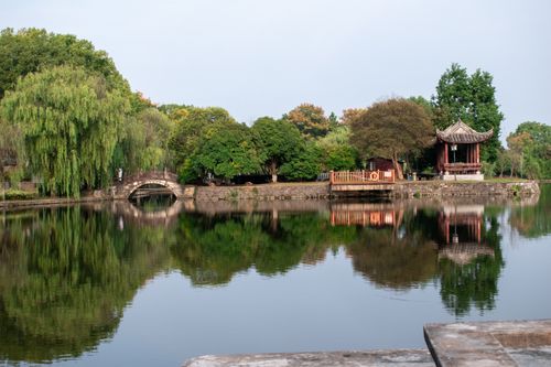 Free Serene view of a traditional Chinese garden with reflections in calm water. Stock Photo